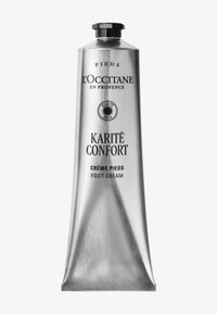 Srebrna metalowa tubka kremu do stóp z czarną nakrętką. Zawiera wytłoczony i nadrukowany tekst, w tym "Karité Confort" i "Crème Pieds".