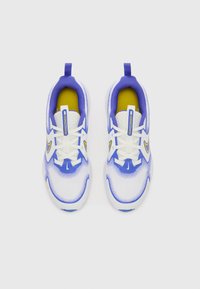 Scarpe da ginnastica blu e bianche con tomaia in rete, dettagli gialli, sistema di allacciatura e design della punta arrotondata. Suola in gomma texturizzata.