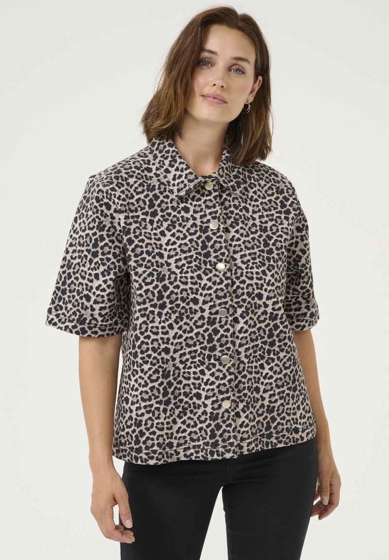 Chemise à manches courtes en imprimé léopard beige et noir, avec un devant boutonné, un col évasé et une coupe décontractée. Tissu doux au toucher.