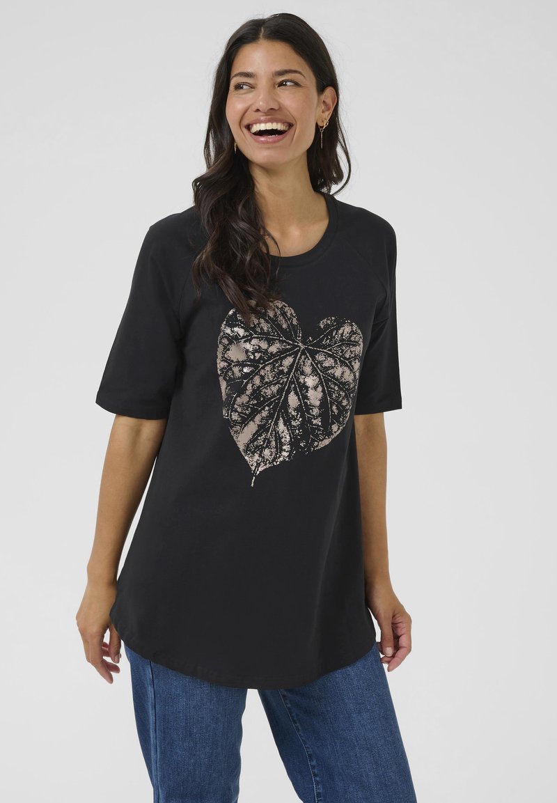 Camiseta negra de manga corta con un gráfico de hoja metálica en forma de corazón. La tela es suave; la camiseta tiene un cuello redondo y un corte holgado.