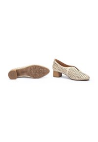 Chaussures en cuir perforé beige avec un petit talon marron. Bout rond et découpes décoratives qui améliorent la texture et le design. Semelle en caoutchouc crantée.
