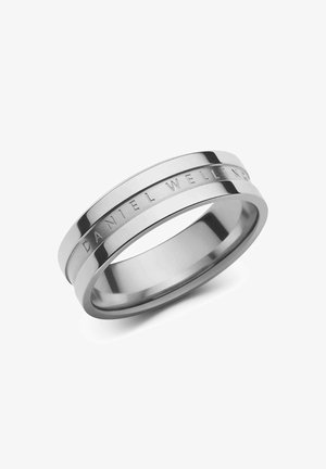 Ruostumattomasta teräksestä valmistettu rengas, jossa on kiillotettu ja harjattu pinta, ja sen nauhassa on kaiverrettu "DANIEL WELLINGTON" -teksti. Pyöreä muoto.