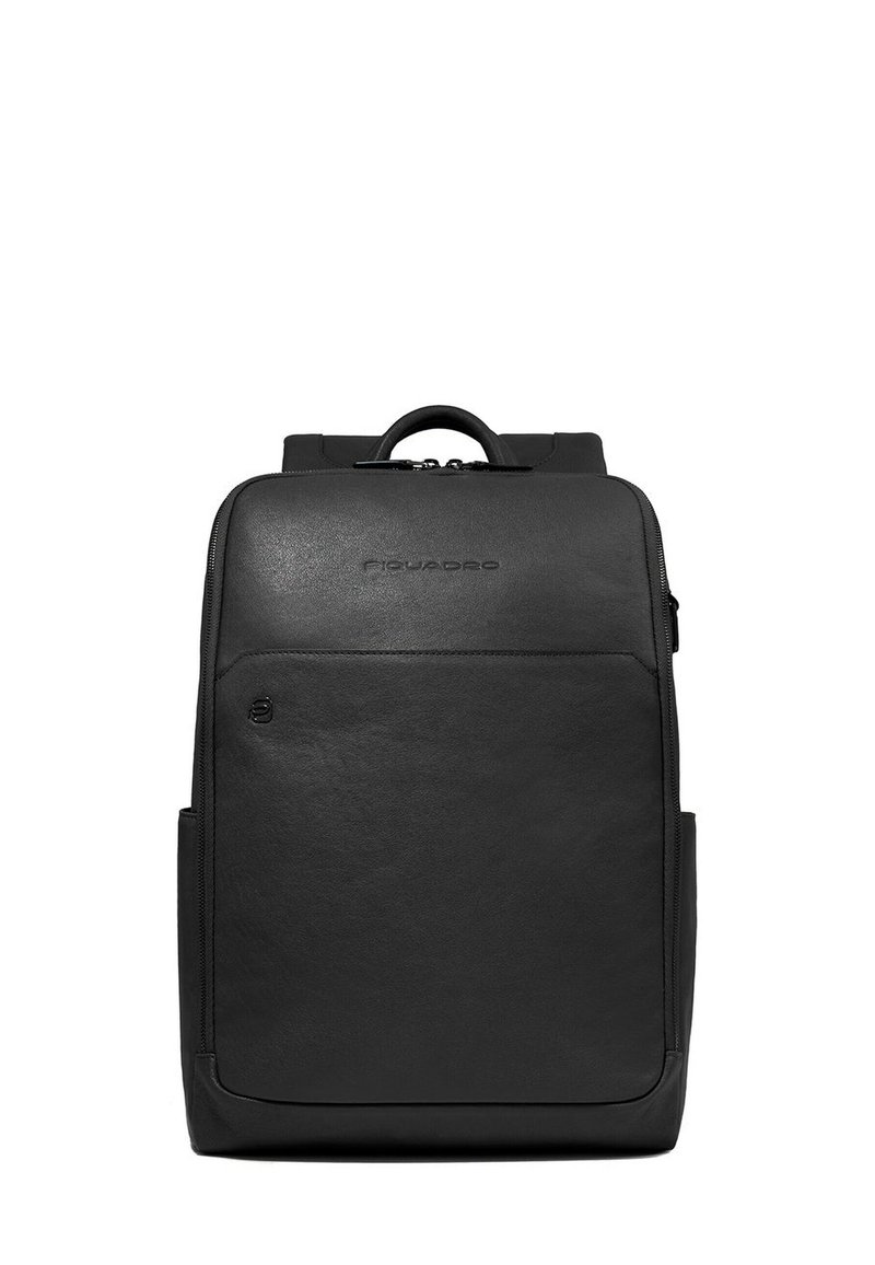 Sac à dos en cuir noir avec une texture lisse, doté d'une poignée supérieure, d'une fermeture éclair et d'une poche avant. Logo discret affiché à l'avant.