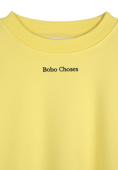 Žlutá bavlněná mikina s žebrovaným výstřihem a černou výšivkou "Bobo Choses" na přední straně. Hladká textura a ležérní design.