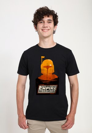 Černé bavlněné tričko s grafickým potiskem helmy a krajiny v oranžové barvě, s nápisem "Star Wars: Impérium vrací úder."