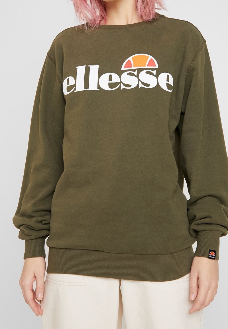Olive green cotton sweatshirt with white "ellesse" logo and orange half-circle accent. Ribbed cuffs and hem for a fitted design.