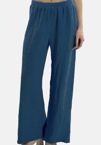 Blaue, weit geschnittene Hosen aus strukturiertem Stoff mit elastischem Bund und seitlichen Taschen. Das Design zeichnet sich durch eine lockere, fließende Silhouette aus.