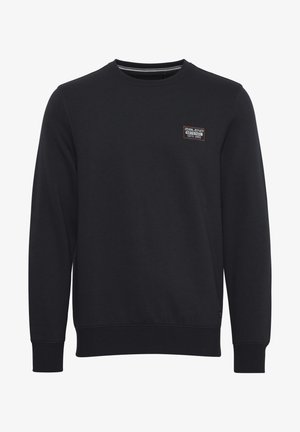 Sudadera negra de cuello redondo hecha de tejido suave, con un pequeño parche de logo en el pecho, puños acanalados y un diseño limpio y simple.