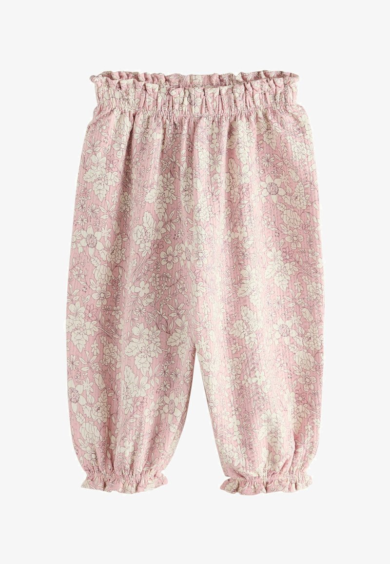 Pantalones elásticos rosas con cintura y tobillos ajustados, con un patrón floral blanco, de corte holgado y puños fruncidos.