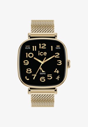 Orologio smartwatch d'oro con quadrante nero quadrato, grandi numeri bianchi, bracciale in rete metallica e indicatori per la data e il livello della batteria.