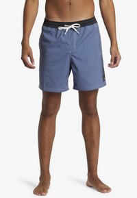 Blaue Swimming-Shorts aus leichtem Stoff. Mit einem schwarzen Bund, weißem Kordelzug und Seitentaschen. Einfaches Design mit kontrastierenden Nähten.