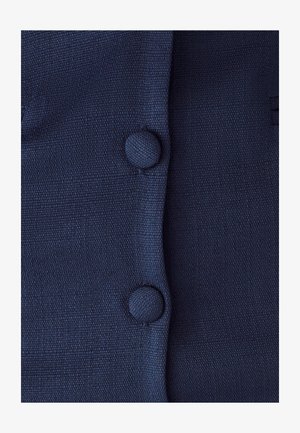 Mørkeblå tekstureret stof med to runde knapper fortil. Materialet ser ud til at være vævet med et subtilt ribbet mønster.