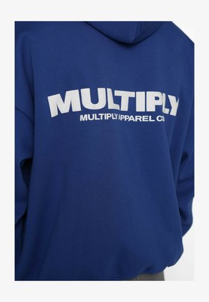 Hanorac albastru cu glugă, având pe spate un logo alb mare „MULTIPLY”, realizat dintr-un material moale, cu croială lejeră și mâneci lungi.