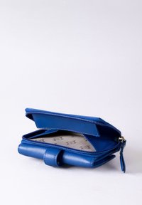 Blue leather wallet with zipper closure, interior card slots, and fabric lining featuring subtle pattern. Compact rectangular shape.