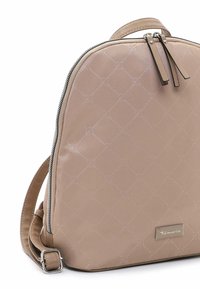 Beige rugzak gemaakt van glad synthetisch materiaal, met een gequilt patroon, zilveren rits en verstelbare schouderbanden. Merkl logo zichtbaar.