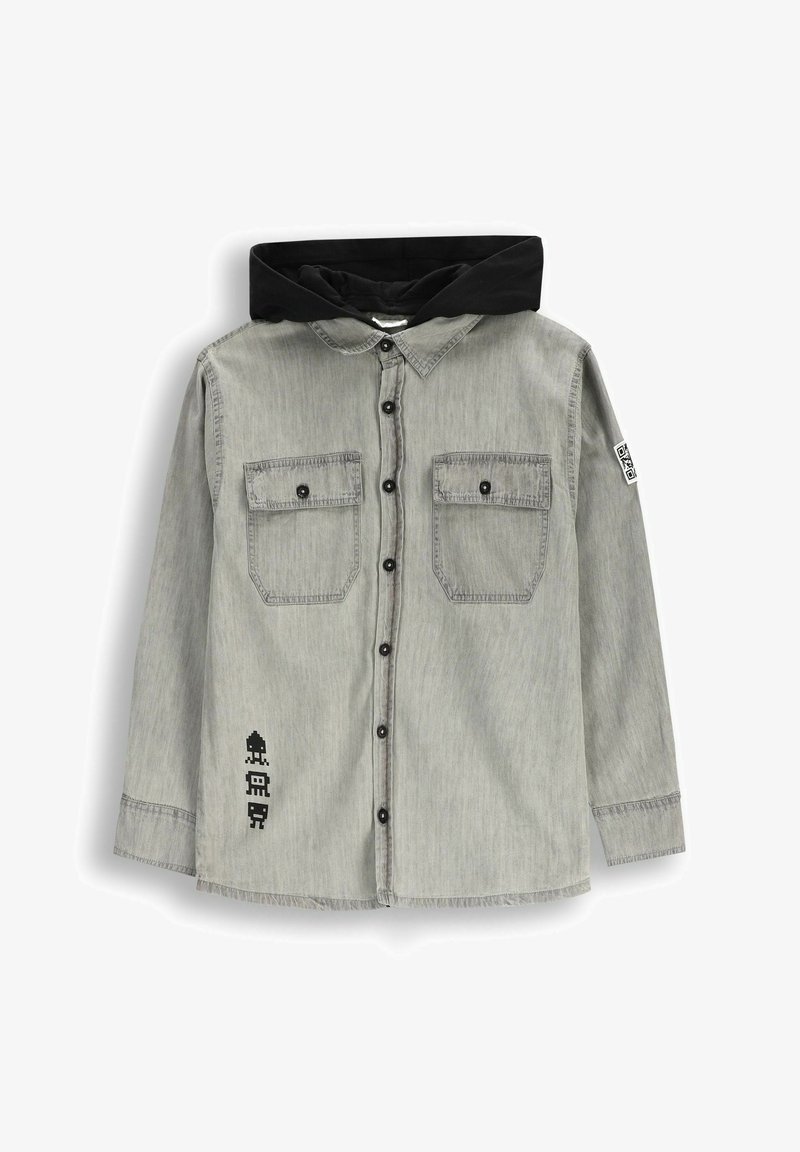 Szara koszula zapinana na guziki z czarnym kapturem. Posiada dwie kieszenie na piersiach, czarne guziki oraz nadruk graficzny na dolnej lewej stronie.