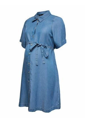 Niebieska sukienka ciążowa z krótkim rękawem wykonana z dżinsu, z przodu zapinana na guziki, z kołnierzykiem i kokardą do wiązania w talii, na białym tle.