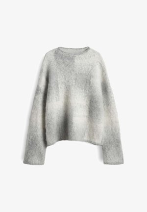 Pull gris et blanc surdimensionné en matière douce et moelleuse, avec un col rond et des manches longues à coupe décontractée.