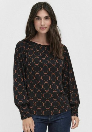 Blouse noire à manches longues avec un motif géométrique orange, en tissu léger. Elle possède un col rond et des détails froncés aux épaules.
