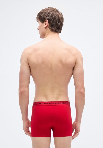 Red cotton boxer shorts with a black waistband featuring the "Polo Ralph Lauren" logo, viewed from the back. Smooth texture and fitted design.