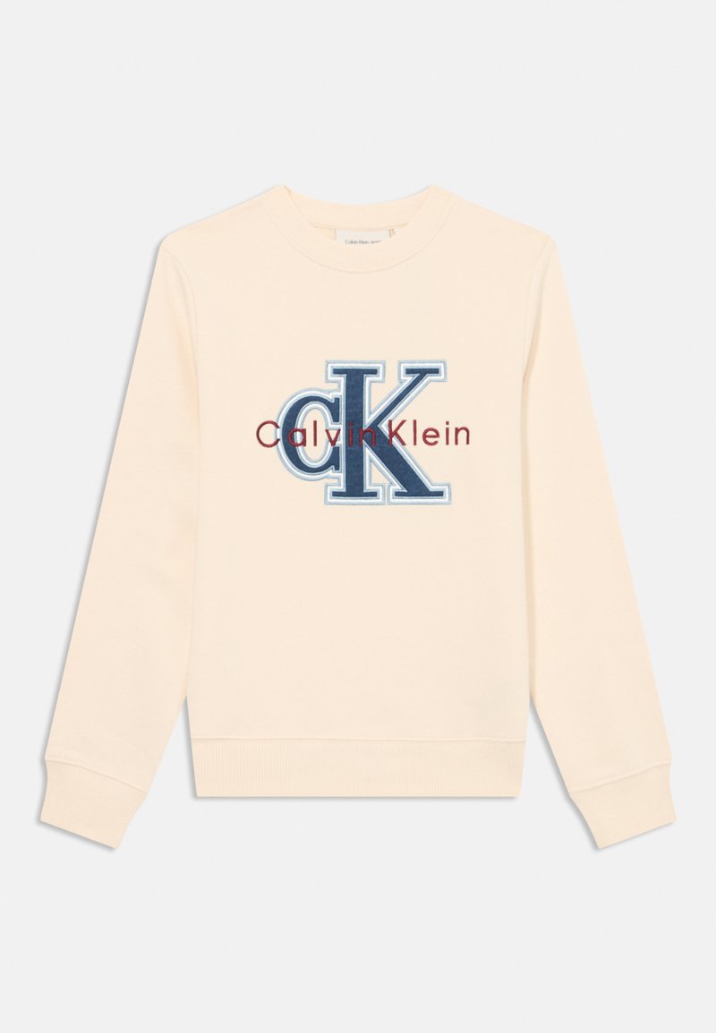 Sudadera de color crema hecha de tejido suave, que presenta un gran logotipo bordado en azul y burdeos con el texto "Calvin Klein" debajo.