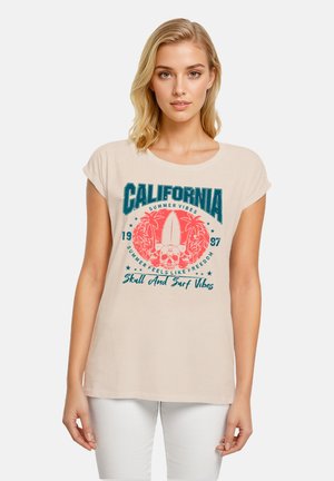 Beige Baumwoll-T-Shirt mit umgeschlagenen kurzen Ärmeln, das ein farbenfrohes Surf-motiv in Türkis und Koralle zeigt, einschließlich eines Schädels und Palmen.