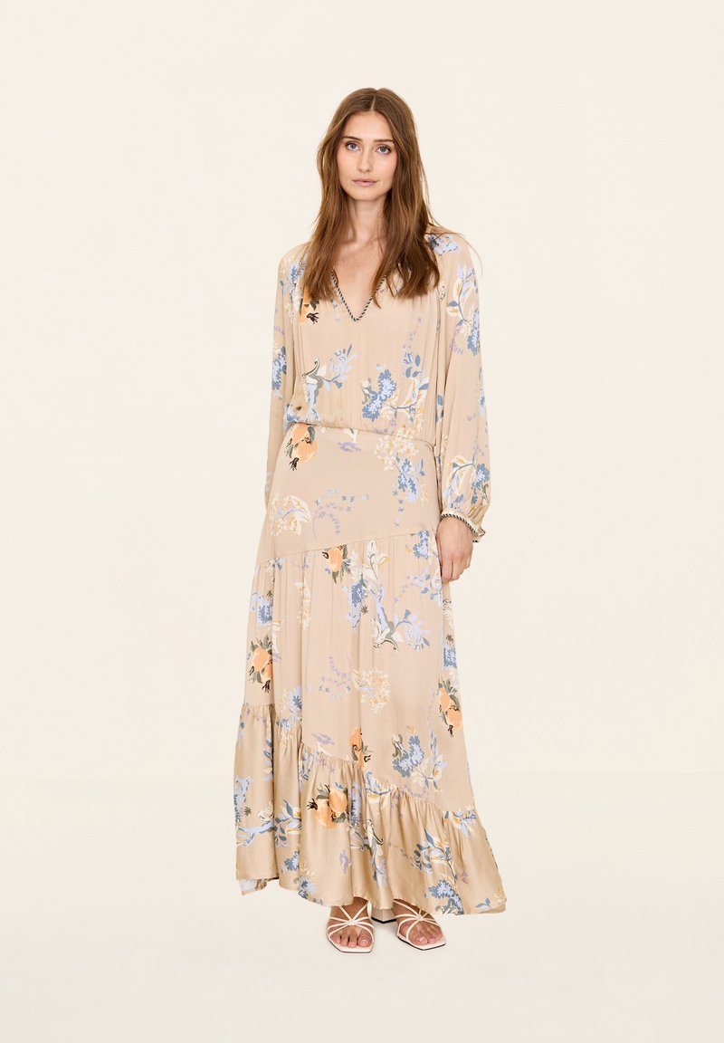 Maxikleid in Beige mit floralen Druck in Blau und Orange. Lange Ärmel, V-Ausschnitt, stufenförmiger Rock und leichtes Material. Mit dezenten Details akzentuiert.