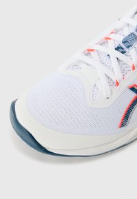 White athletic shoe with mesh upper, featuring blue and orange accents. The sole is textured and slightly curved for support.