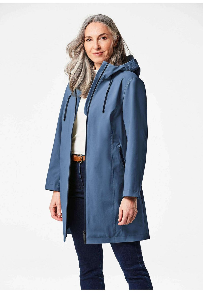 Blauwe waterdichte jas met een capuchon, vooraan voorzien van een rits en twee zijzakken. De jas heeft een gestroomlijnd ontwerp en een zachte textuur.