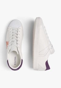 Zapatillas blancas con una suela texturizada, cordones grises y acentos morados en el talón. Incluyen un logo naranja en el lateral y detalles perforados.