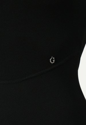 Schwarzes Sportoberteil mit geripptem Material, das ein dezentes silbernes Logo an der Seite und ein elegantes, eng anliegendes Design aufweist.