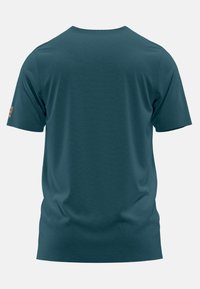 Camiseta verde azulado hecha de tela suave, con cuello redondo y mangas cortas. Los acentos notables incluyen un pequeño parche de logo en la manga izquierda.