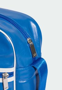 Rucsac albastru lucios cu o suprafață texturată, având un fermoar și elemente din metal argintii, accente albe și o curea solidă albastră.