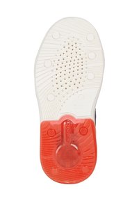 Semelle extérieure de baskets blanches avec un design texturé, dotée d'une section circulaire rouge et de petits trous de drainage pour la respirabilité.