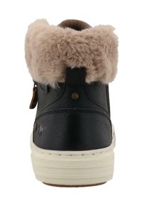 Zapatillas negras de piel sintética con un puño de pelaje sintético beige, que cuentan con una suela de goma blanca y detalles de botones en bronce. Vista trasera.