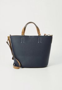 Tmavomodrá kožená kabelka s texturovaným povrchem, vybavená držadly z hnědé kůže, odnímatelným ramenním popruhem a minimalistickými designovými prvky.