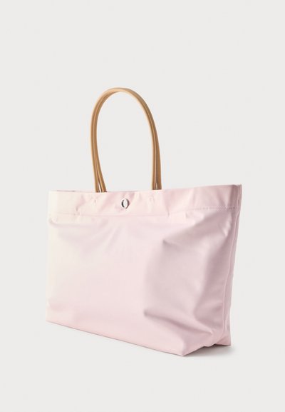 Ανοιχτό ροζ τσάντα ώμου με ταμπά λαβές και μικρό ασημένιο κουμπί στο κέντρο επάνω μέρος, εμφανίζεται σε απλό φόντο.