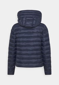 Veste matelassée marine avec des coutures horizontales, une capuche intégrée et une texture lisse. Présente une coupe ajustée avec des détails matériels minimaux.