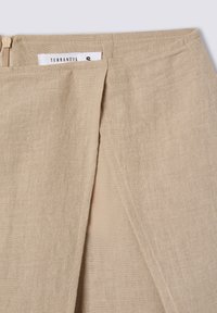 Gonna di lino beige con forma ad A, caratterizzata da una piega frontale e chiusura a zip nascosta. L'etichetta riporta "Terranova" con taglia "S".