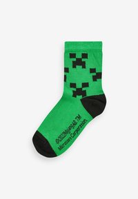 Zielona bawełniana skarpetka z czarnym pikselowym wzorem creepera. Czarny akcent na palcach i pięcie z tekstem ©2022 Mojang AB i Microsoft Corporation.