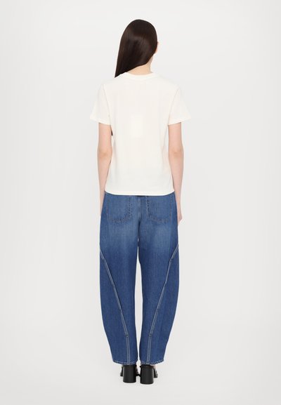 Weißes Baumwoll-T-Shirt und lässige blaue Jeans aus Denim mit Seitennähten, kontrastierendem Stich und versteckten Taschen; schlichte Ausführung mit kurzen Ärmeln.
