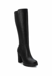 Botas negras hasta la rodilla hechas de cuero suave. Tacón grueso y bloque con suela texturizada. Presenta costuras mínimas y un detalle lateral.