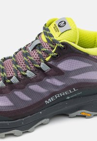 Chaussure de randonnée Merrell avec une tige en mesh gris et violet, des accents jaune vif, une semelle en caoutchouc robuste et une marque Gore-Tex imperméable.