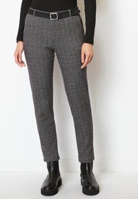 Skräddarsydda grå hundtandsmönstrade byxor med smal passform, slät framdel och svart bälte. Texturerat tyg med subtilt mönster och ankellängd.