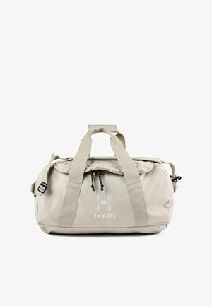 Beige Haglöfs duffelbag met dubbele handvatten, voorvak met ritssluiting, verstelbare schouderriem en logo middenvoor.