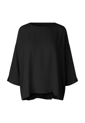 Blusa nera a maniche lunghe, vestibilità ampia, con scollo rotondo ampio e orlo leggermente curvo.
