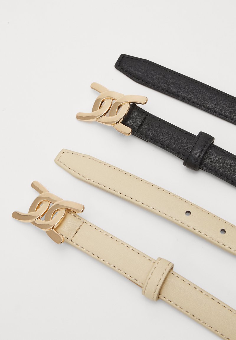 Trois ceintures : en cuir noir, en cuir crème, toutes deux avec des boucles en métal doré ; texture lisse ; réglables avec des trous.