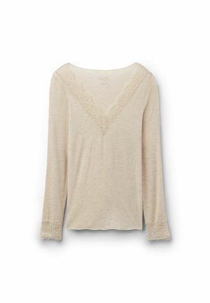 Top beige de manga larga con escote en V y ribete de encaje en el escote y los puños, mostrado sobre un fondo blanco liso.