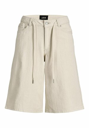 Bézs térdig érő rövidnadrág függőleges varrott csíkokkal, elöl gombbal, cipzárral, övbújtatókkal, húzózsinórokkal és oldalzsebekkel.