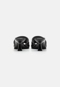 Zapatos de tacón alto negros con parte superior redondeada y plisada, y un tacón anguloso y estrecho, con un acabado suave y brillante y una silueta elegante.